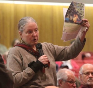 Marilyn Hunt holds up a picture of a flaming gas well at a public meeting (click to enlarge)