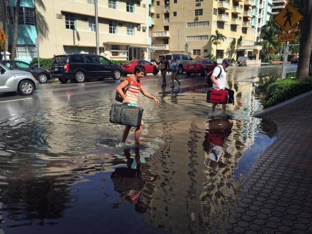 Tourists navigate the flooded streets of Miami during a king tide in 2015. Climatologists say these king tides will be normal high tides soon. Photo Emily Michot, Miami Herald